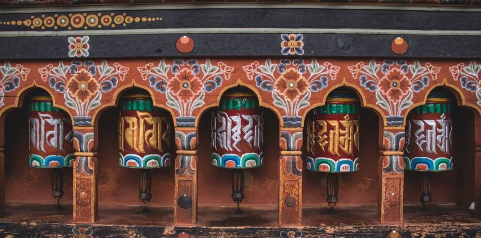 Colorful Buddhist prayer wheels with intricate designs from Bhutanese temple.