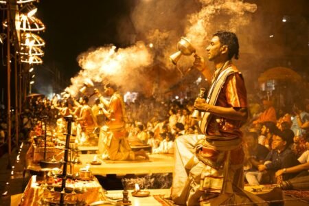 A captivating scene of priests performing the Ganga Aarti on the Ghats of Varanasi during night.