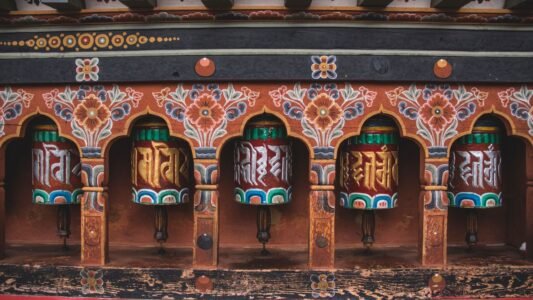 Colorful Buddhist prayer wheels with intricate designs from Bhutanese temple.